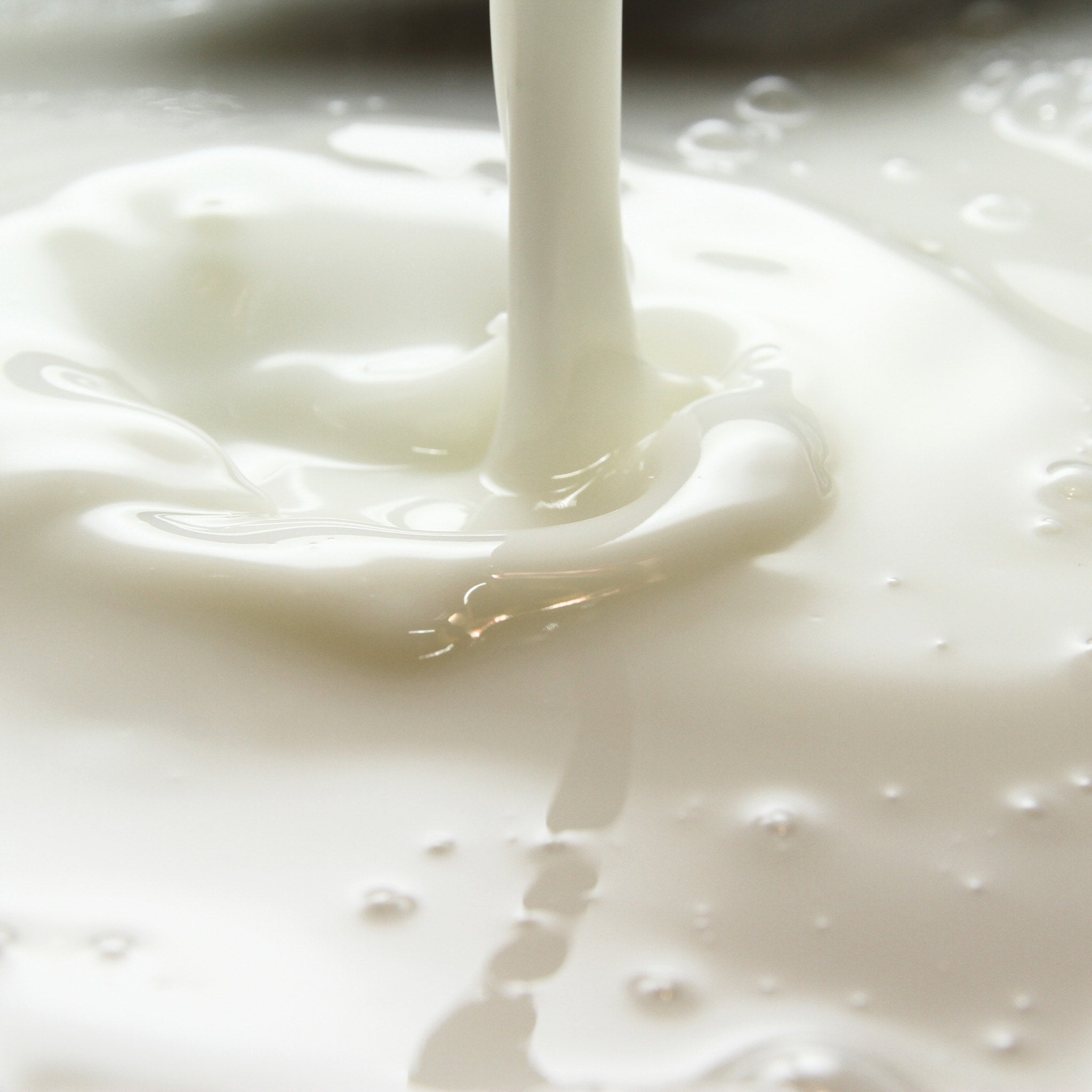 Close-up of a smooth, creamy goat milk soap splashing as it pours. Close-up of a smooth, creamy goat milk soap splashing as it pours.