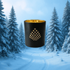 Black candle holder with gold interior in a snowy forest