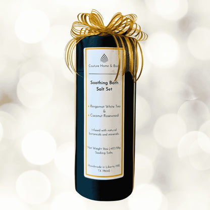 Bath salt gift set packaging with gold ribbon on a white background.