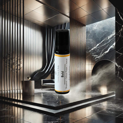 A rollerball perfume labeled "Bold" by Couture Home & Body is displayed in front of a sleek, modern interior with black marble and metallic accents, evoking an atmosphere of confidence and sophistication.