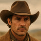Man wearing a brown cowboy hat and coat in a desert setting