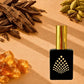 A perfume bottle surrounded by oud, cardamom pods, and amber resin crystals.