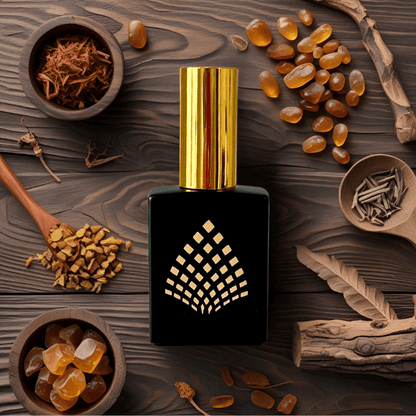Perfume bottle with gold cap on a wooden surface with amber-colored ingredients.