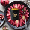 Luxury home fragrance–Golden Rhubarb candle infused with pomegranate, sage & honey in a matte black jar with gold interior.