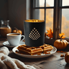 Black mug with geometric design, waffles, and coffee on a wooden table with autumn decor.