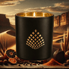 Luxury home fragrance–Nomad candle infused with sicilian mandarin, orris, and musk in a black jar with gold interior.