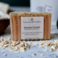 A bar of Oatmeal Coconut soap made with organic goat’s milk, topped with oatmeal flakes, and labeled as sulfate and phthalate-free.