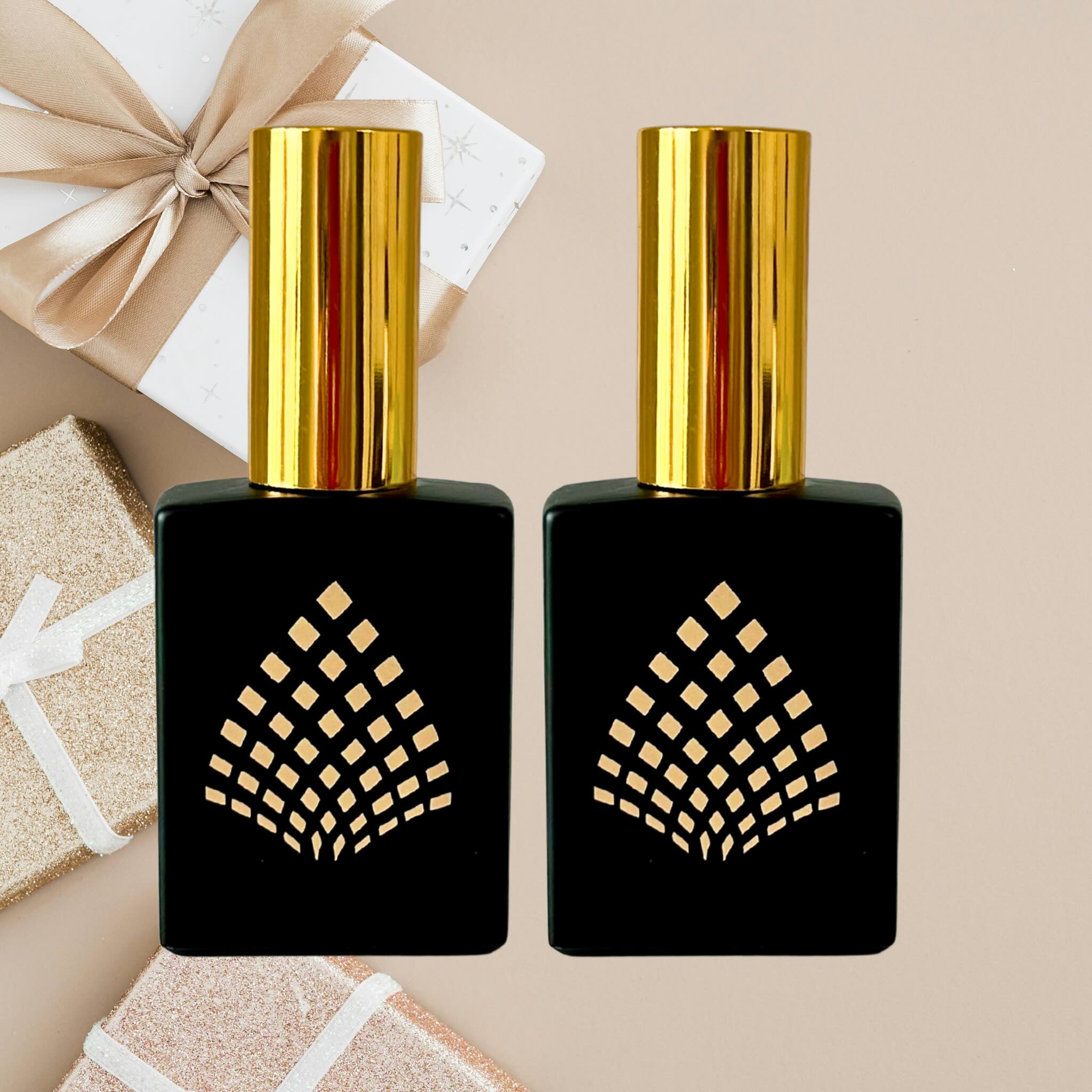 Two black perfume bottles with gold caps on a beige background.