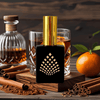 Perfume bottle with a glass of whiskey, orange, cinnamon sticks, and a decanter on a wooden surface.