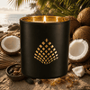 Black candle jar against a beach background with coconuts.