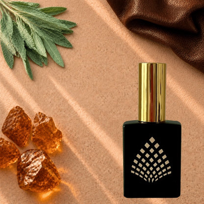 A black perfume bottle styled on a warm beige surface with sage leaves, amber, and brown leather.